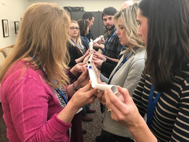 A group of people are holding a tube in their hands.