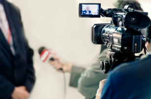 A man in a suit is being interviewed by a cameraman