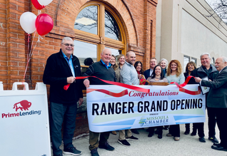 A group of people are holding a banner that says ranger grand opening