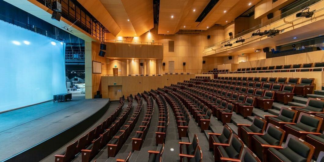 A large auditorium with rows of seats and a stage.