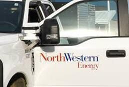 Two northwestern energy trucks are parked next to each other.