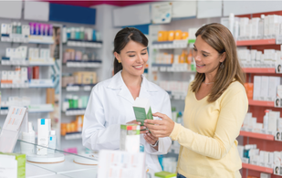 A female pharmacist is talking to a woman in a pharmacy.