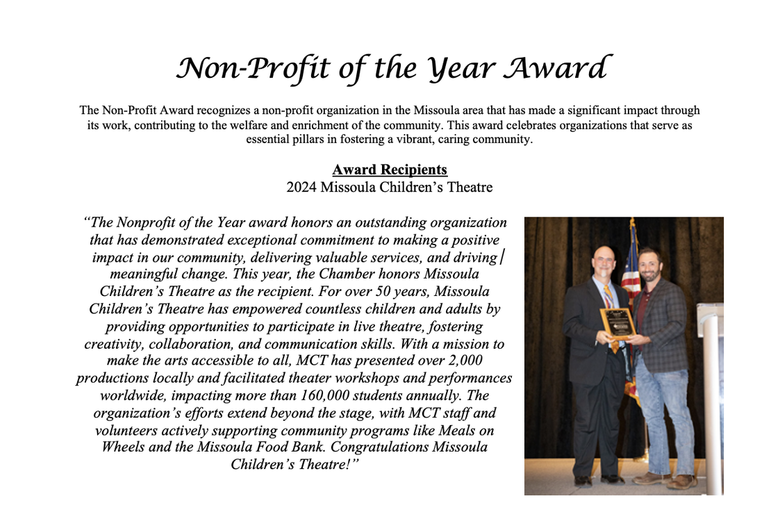 A man and woman are holding a non profit of the year award.