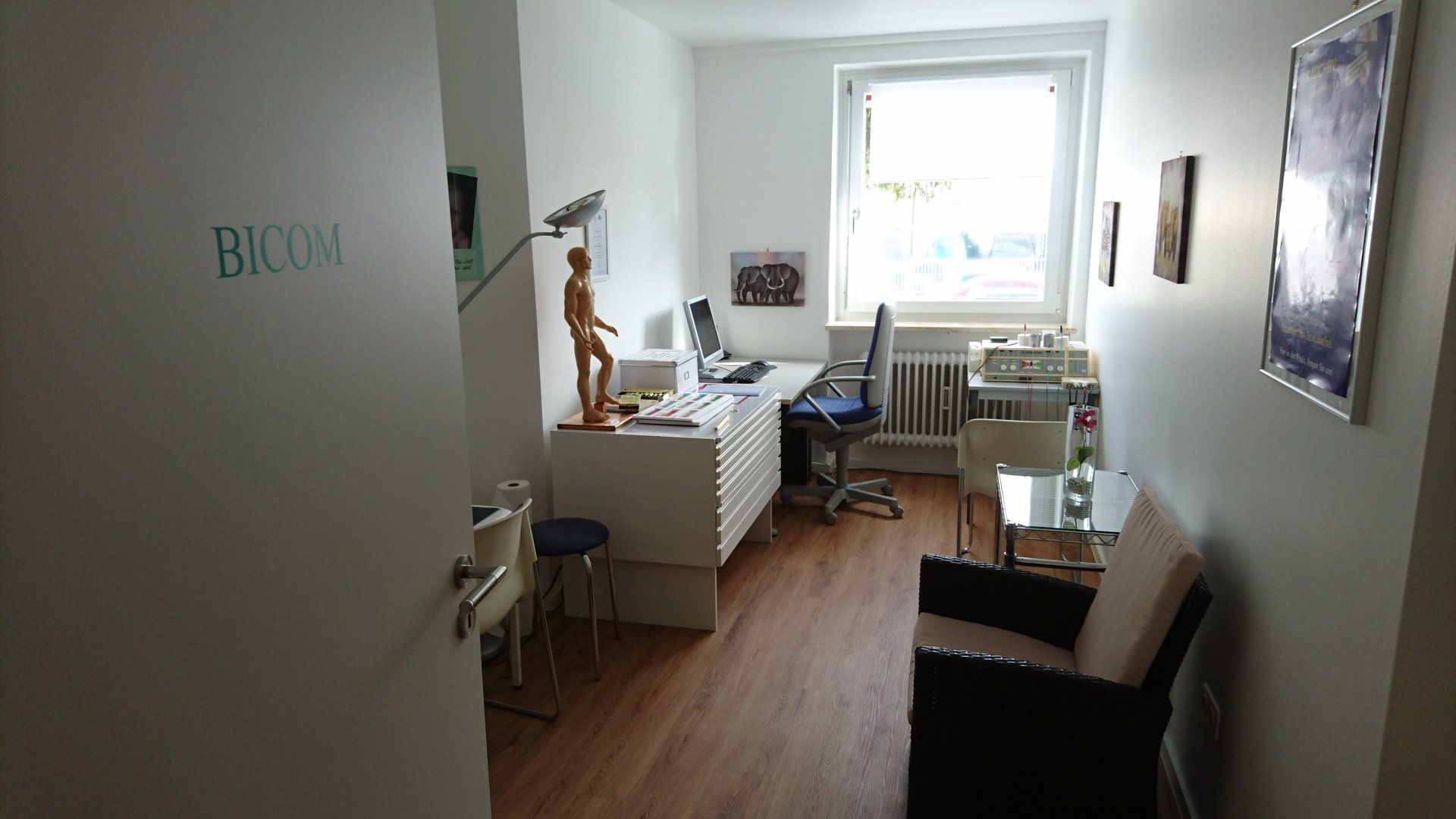 Ein Zimmer mit einem Stuhl und einem Schreibtisch mit dem Wort „Bicom“ an der Wand