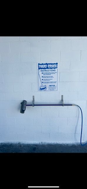 A white wall with a sign on it and a hose attached to it.