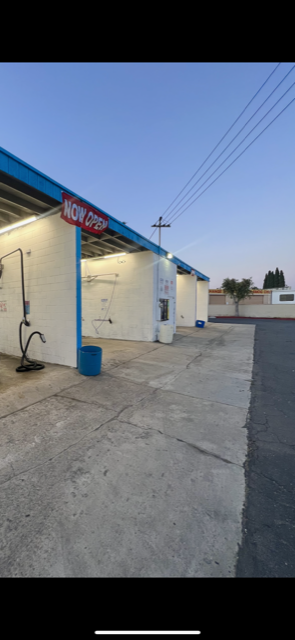 A car wash with a sign that says now open