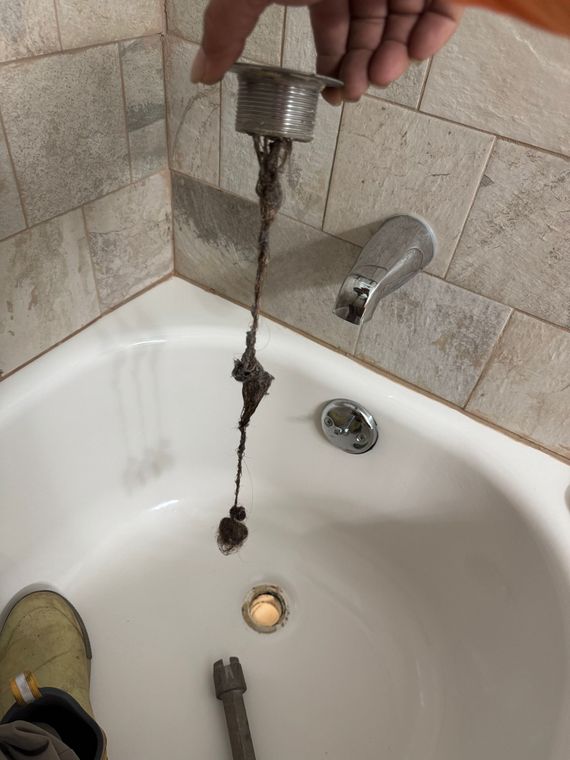 Bathroom sink with brushed nickel faucet, white quartz countertop, and rustic wood-framed mirror.