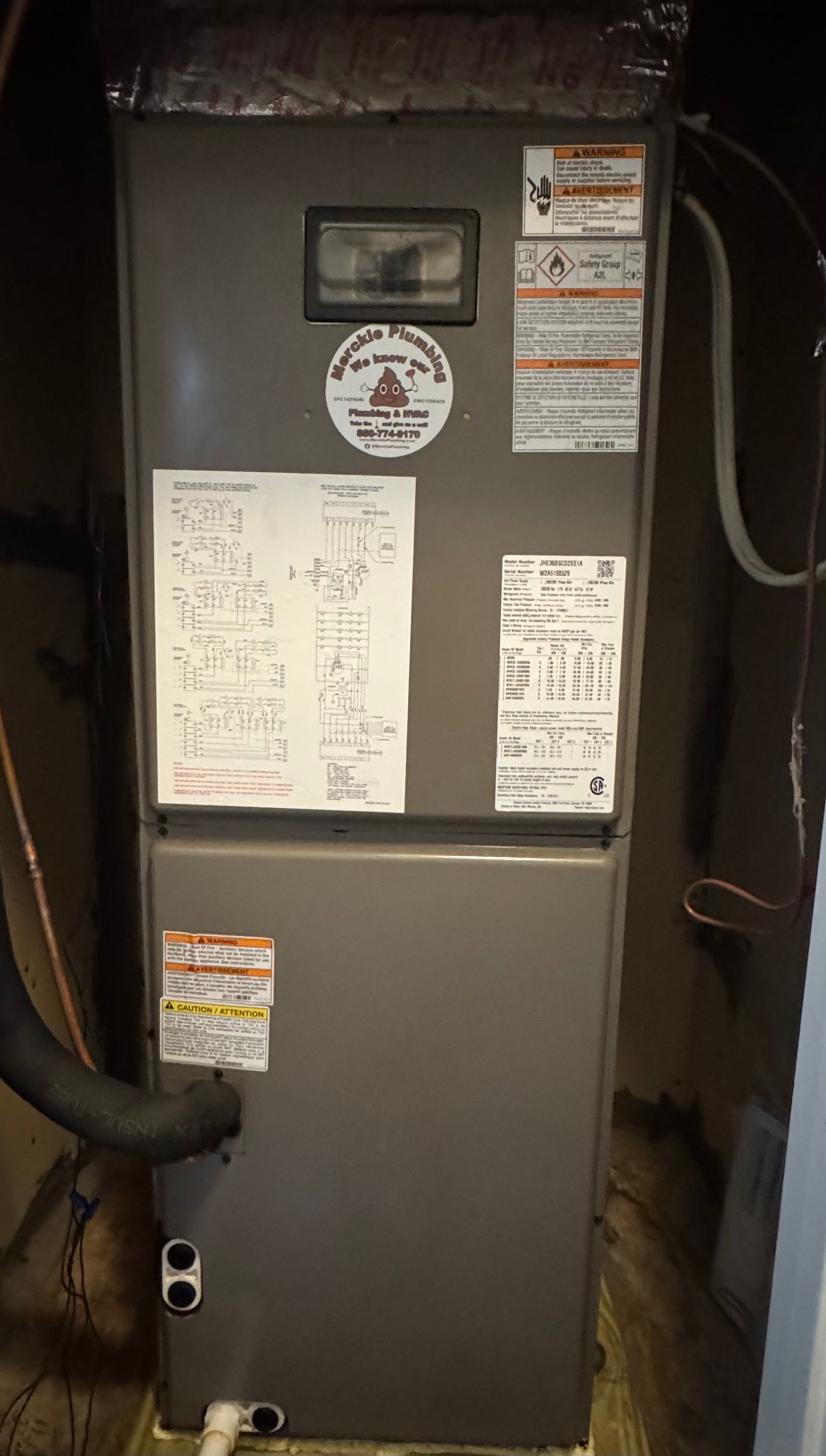 Gray furnace in a basement setting, with labels and ductwork.
