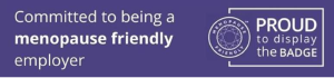 A purple sign that says committed to being a menopause friendly employer