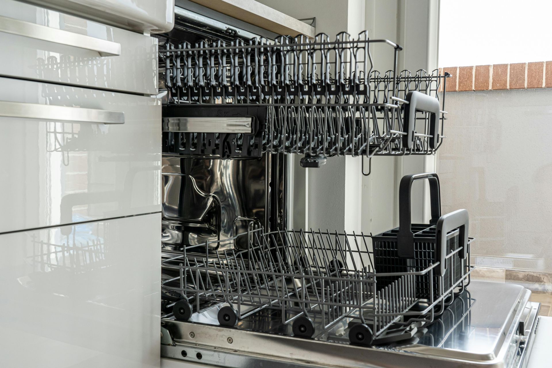 An open dishwasher in a kitchen with the door open.