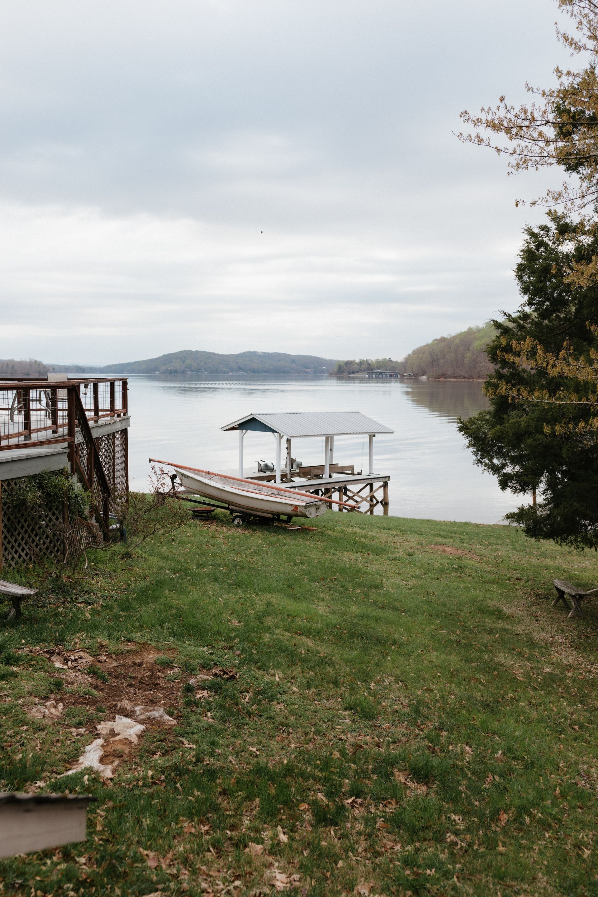 There is a dock on the shore of a lake.