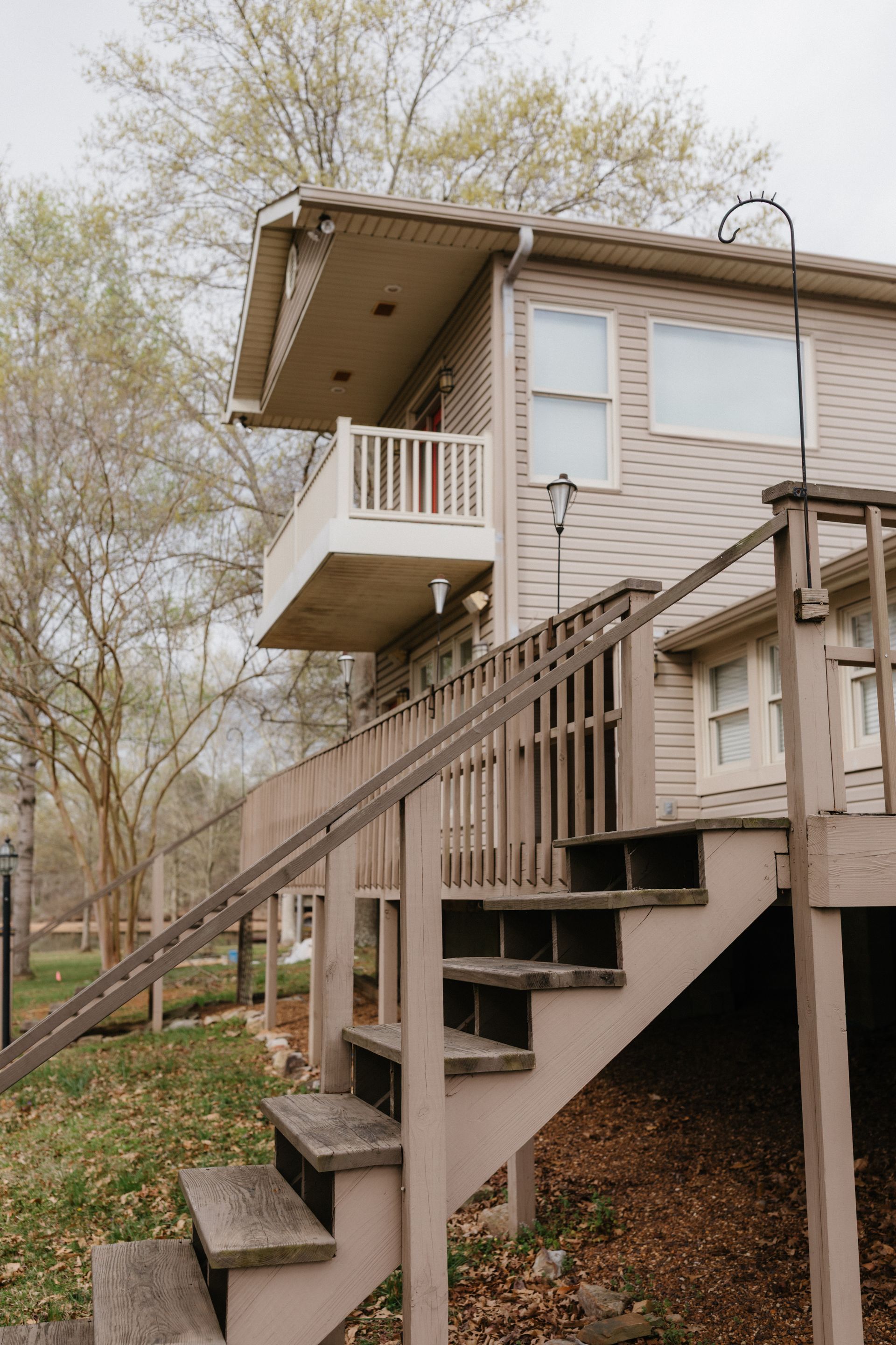 A house with stairs leading up to the second floor and a balcony.