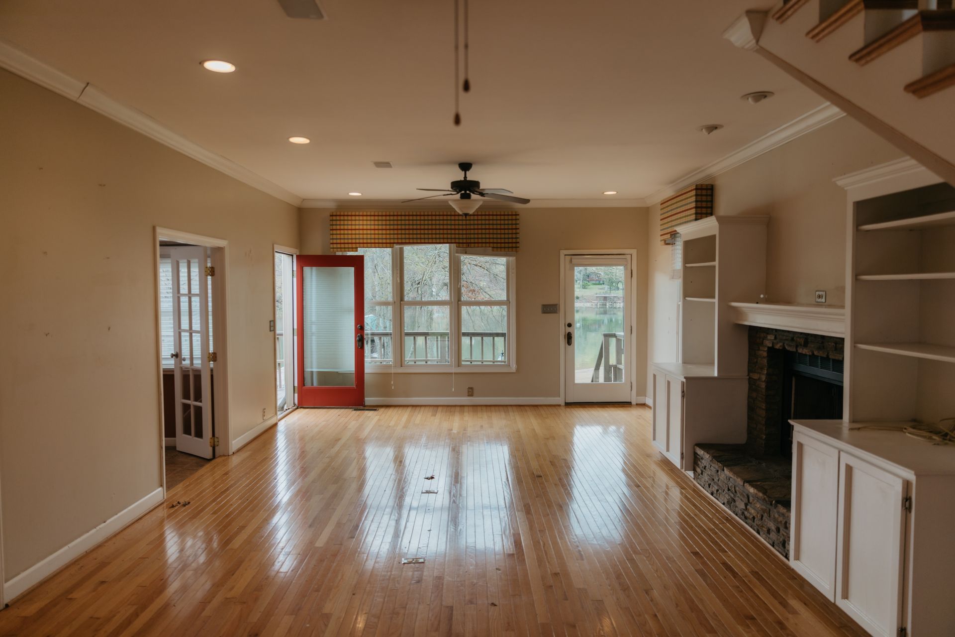 An empty living room with hardwood floors and a fireplace.