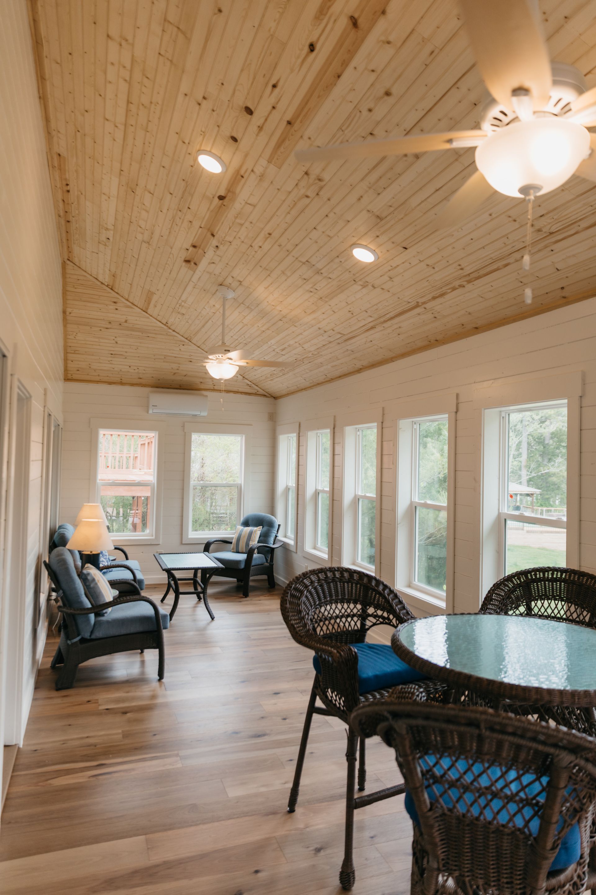 A living room with a table and chairs and a ceiling fan.