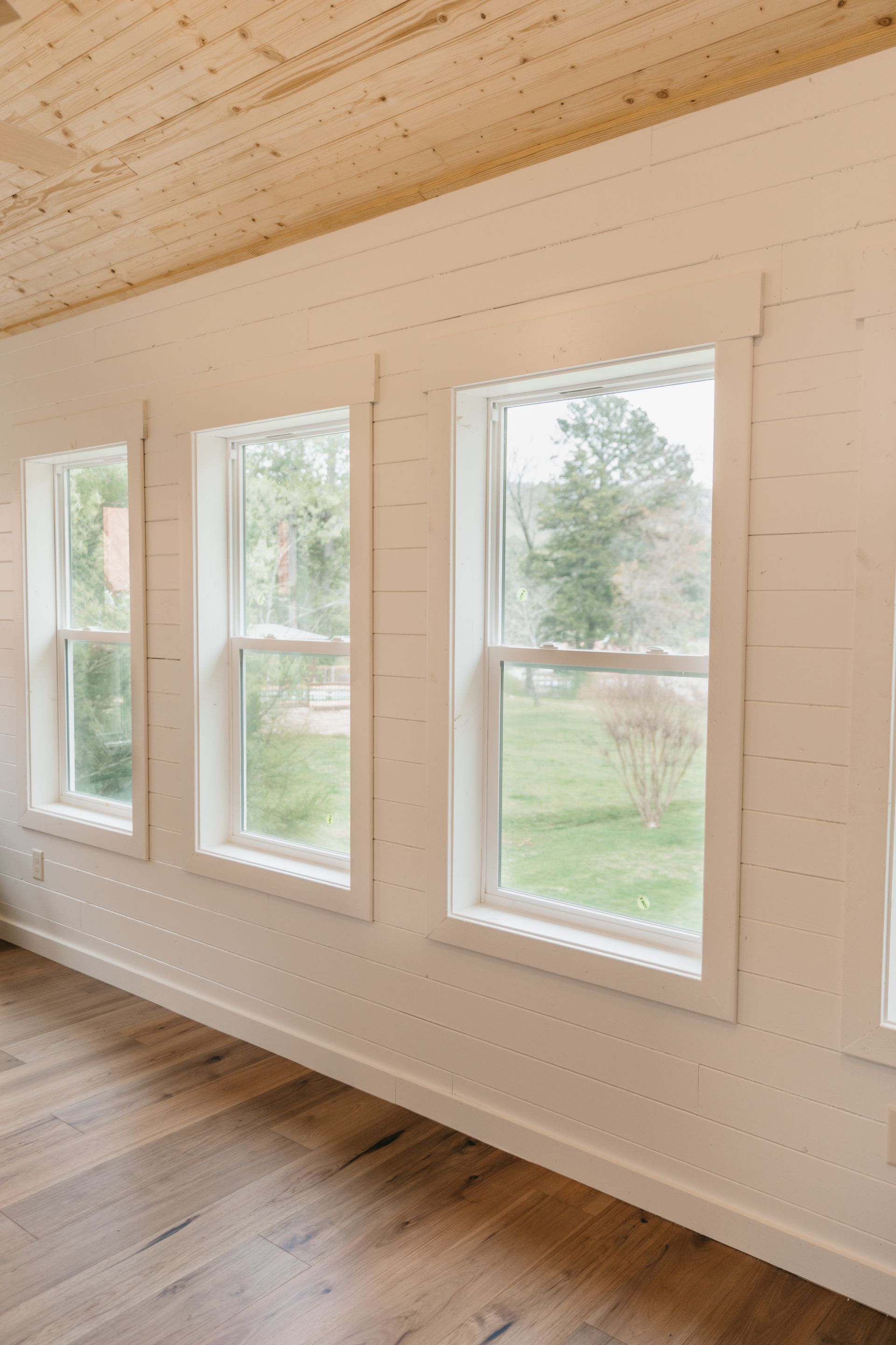 A room with a lot of windows and a wooden ceiling.