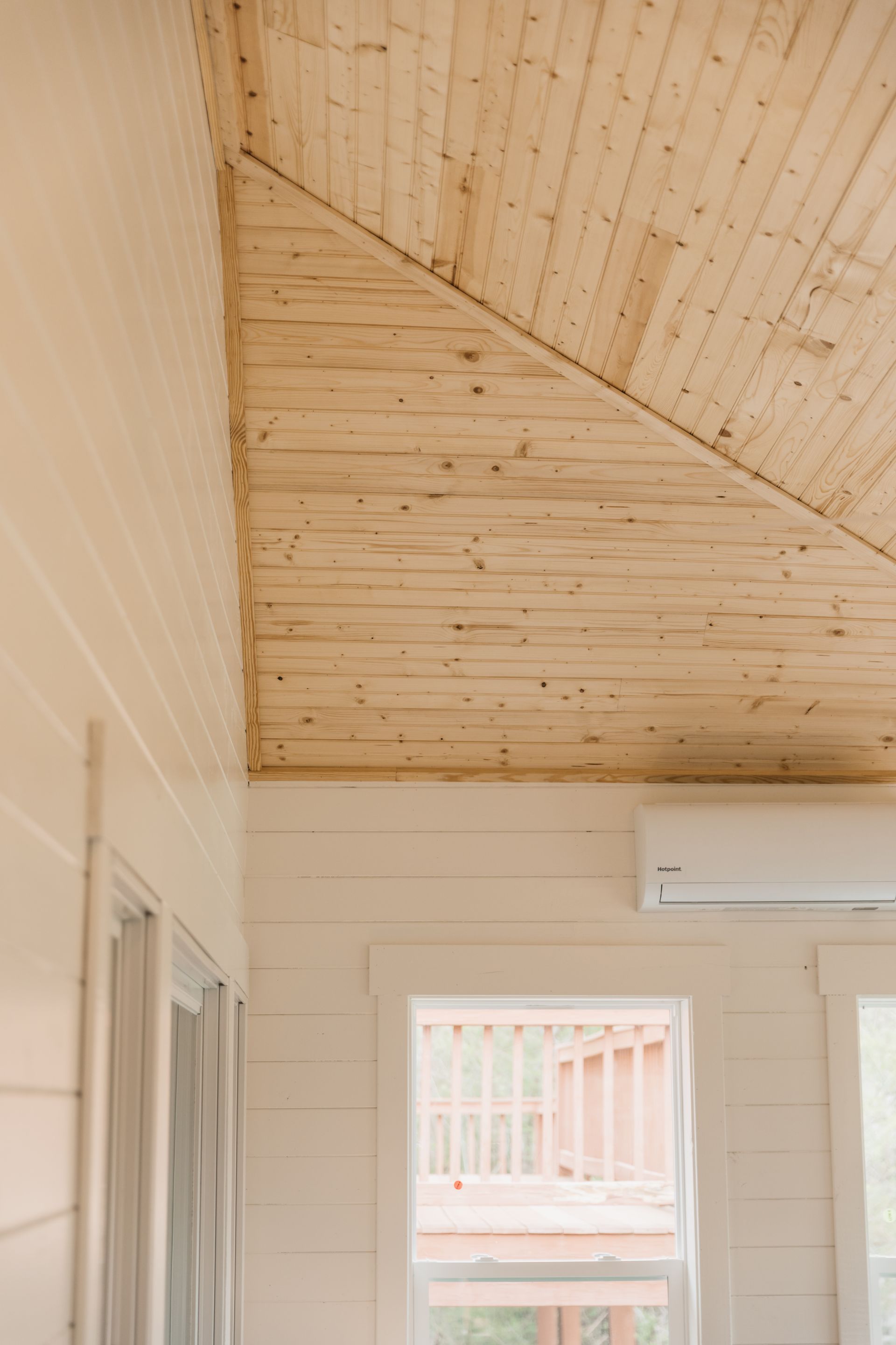 A room with a wooden ceiling and a window.