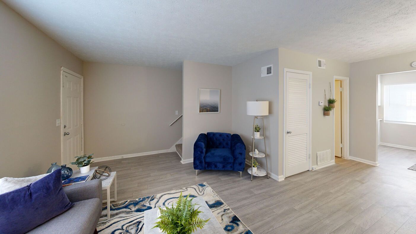 Living room with gray walls, blue armchair, and patterned rug.