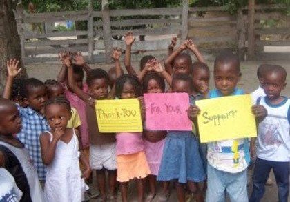 A group of children are holding up signs that say thank you for your support