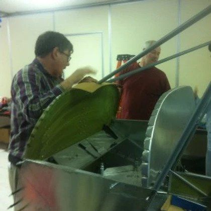 A man in a plaid shirt is working on a boat