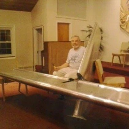 A man sits in a chair in front of a table