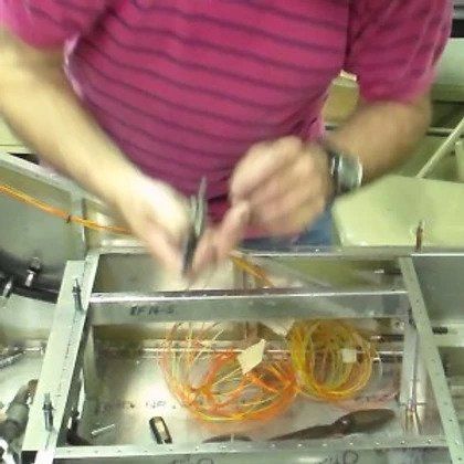 A person in a pink shirt is working on a machine