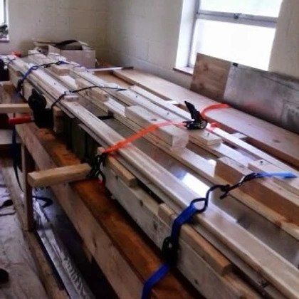 A bunch of wooden boards are tied together with straps in a room.