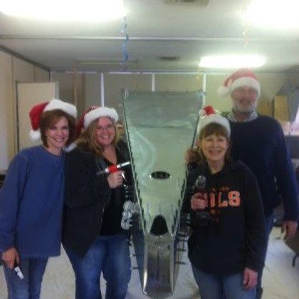 A group of people wearing santa hats are posing for a picture