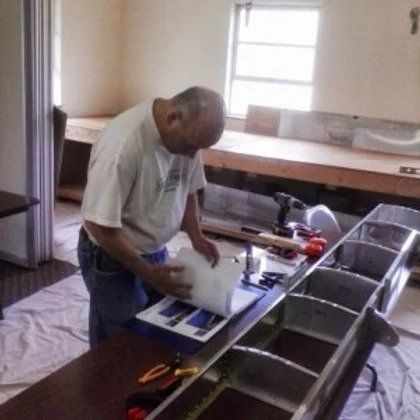 A man is working on a sink in a kitchen