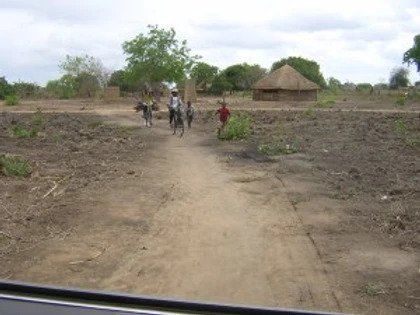 A group of people walking down a dirt road