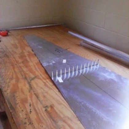 A piece of metal is sitting on top of a wooden table.