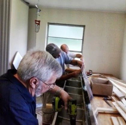 A group of men are working on a boat in a room.