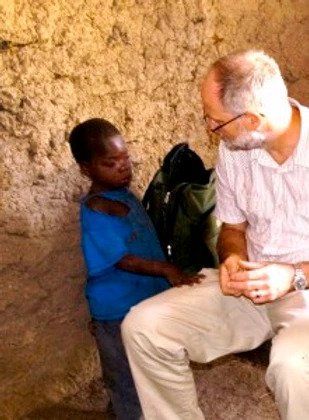 A man is sitting next to a little boy in a blue shirt