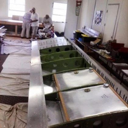 A group of men are working on a stainless steel counter top