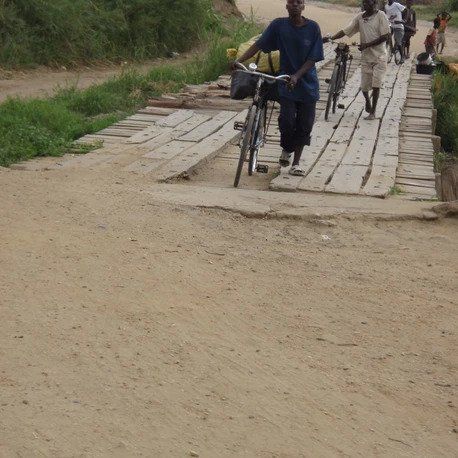 A man riding a bike on a wooden bridge