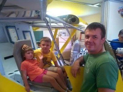 A man and two children are sitting in a plane.
