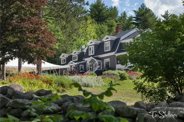 A large house with a stone wall in front of it