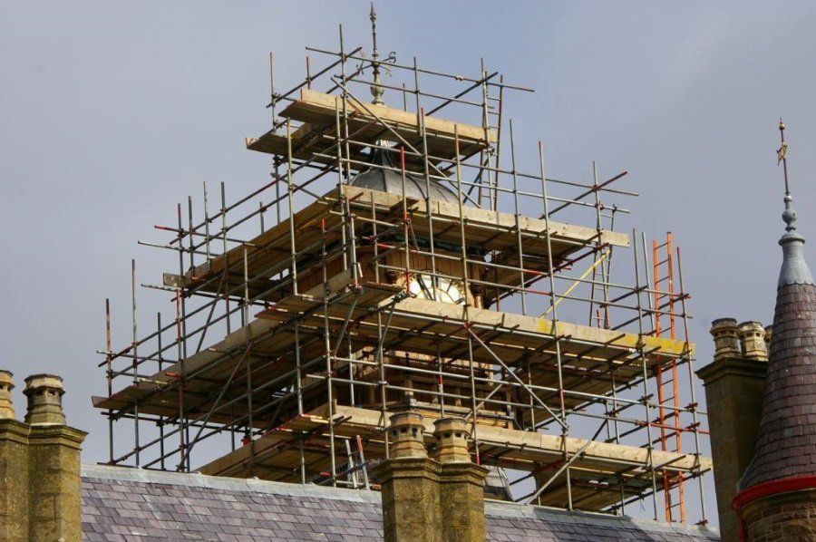 A clock tower is being built with scaffolding on top of it