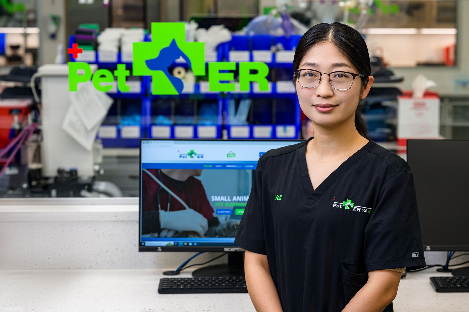 Veterinary operating room with stainless steel tables and gray cabinets; lime green accents.