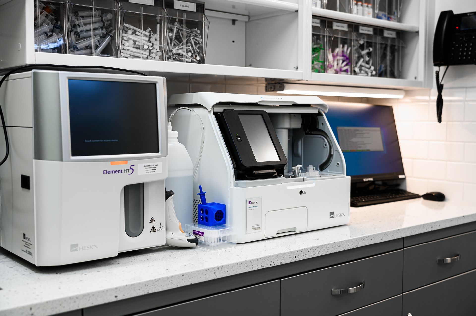 Medical equipment, including a blood analyzer, sits on a countertop in a lab.