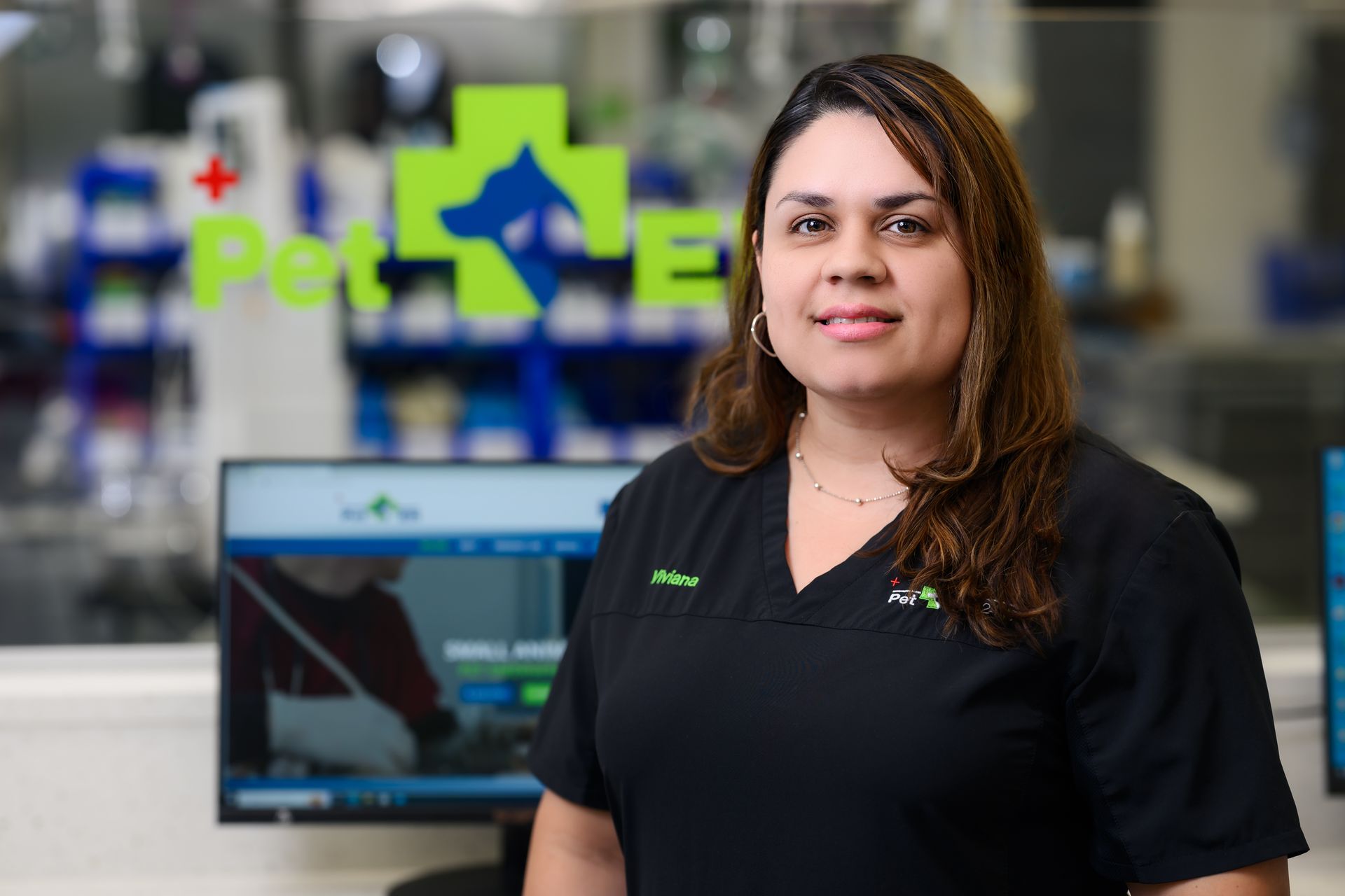 Surgical suite: stainless steel door, operating table, medical equipment, bright lights, white cabinets, green wall.