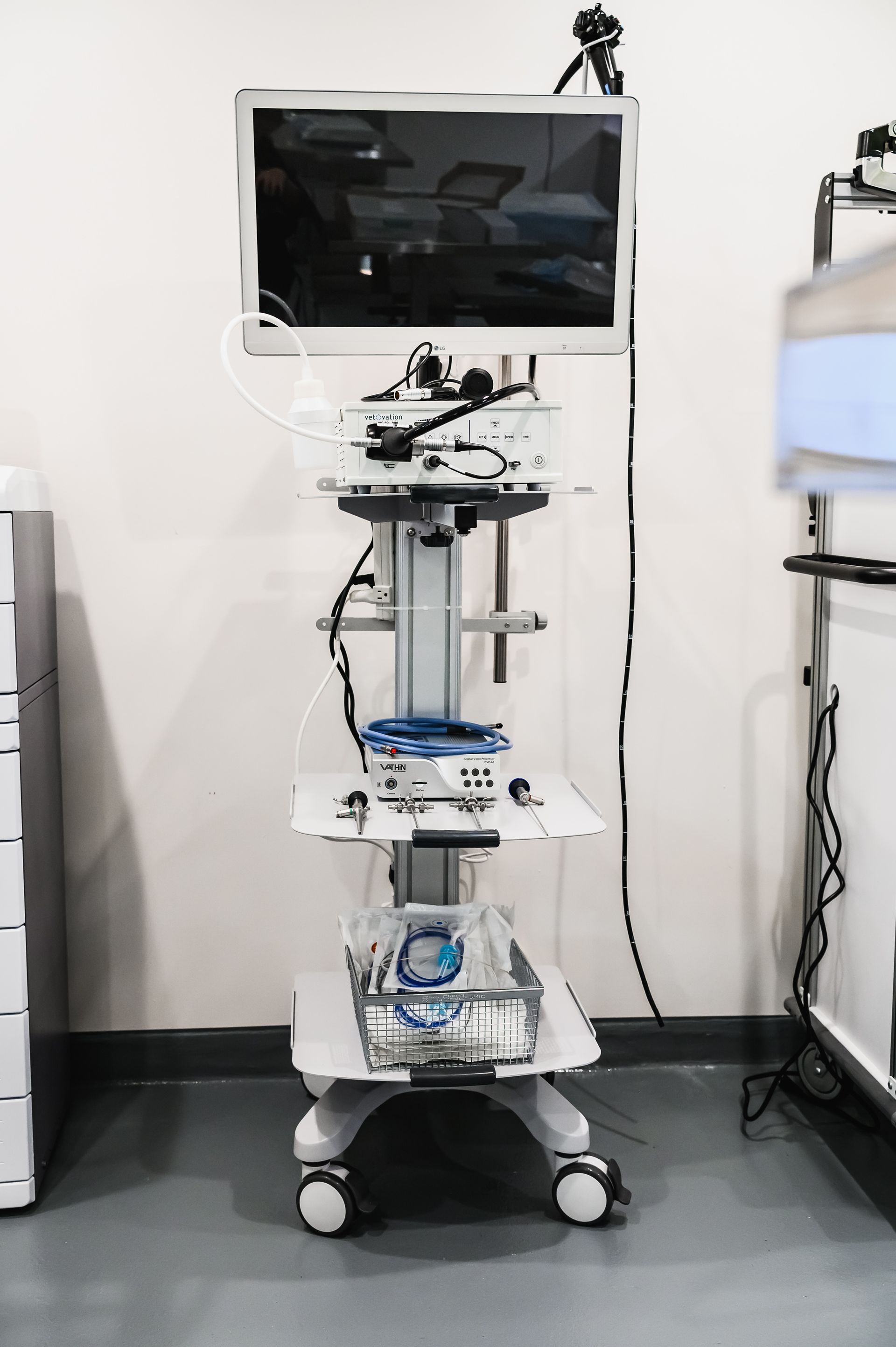 Medical cart with monitor and equipment in a clinical setting.