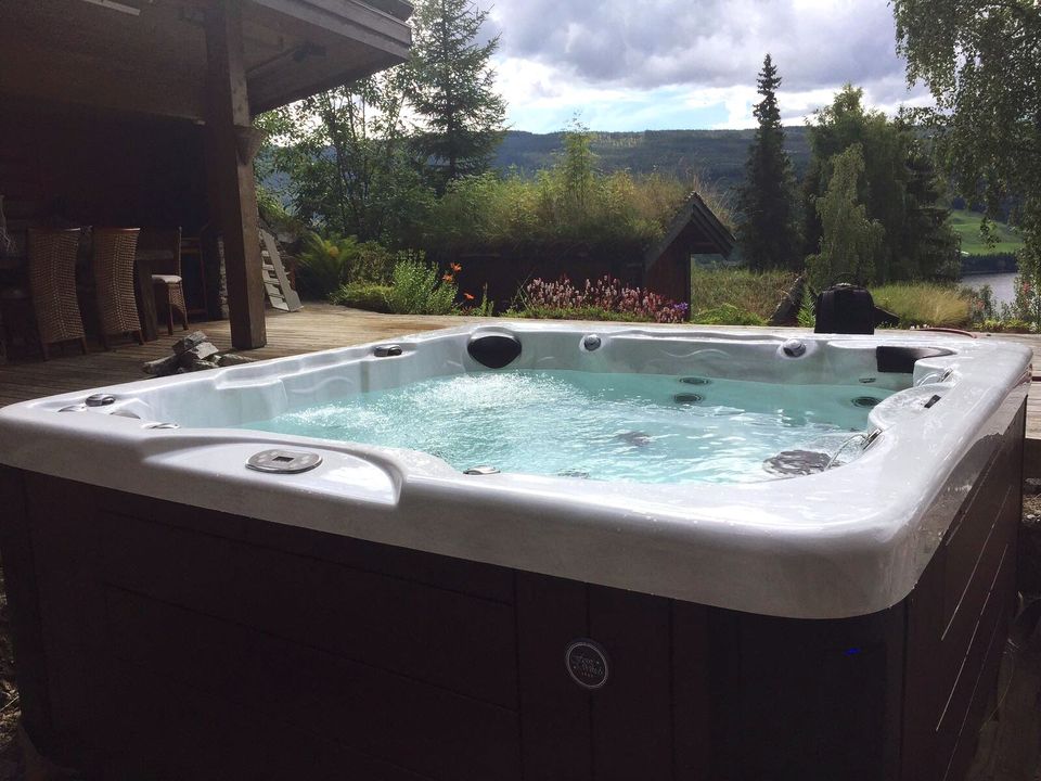 A hot tub is sitting on a patio next to a house.