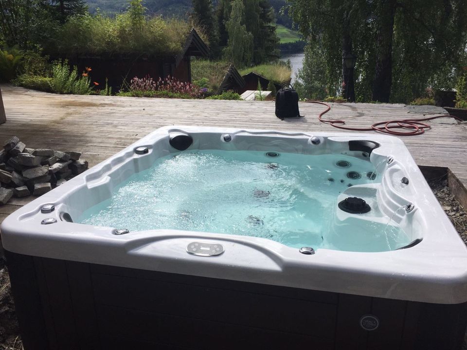 A hot tub is sitting on top of a wooden deck.