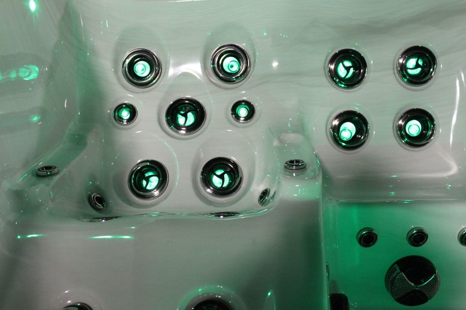 A close up of a hot tub with green lights on it.