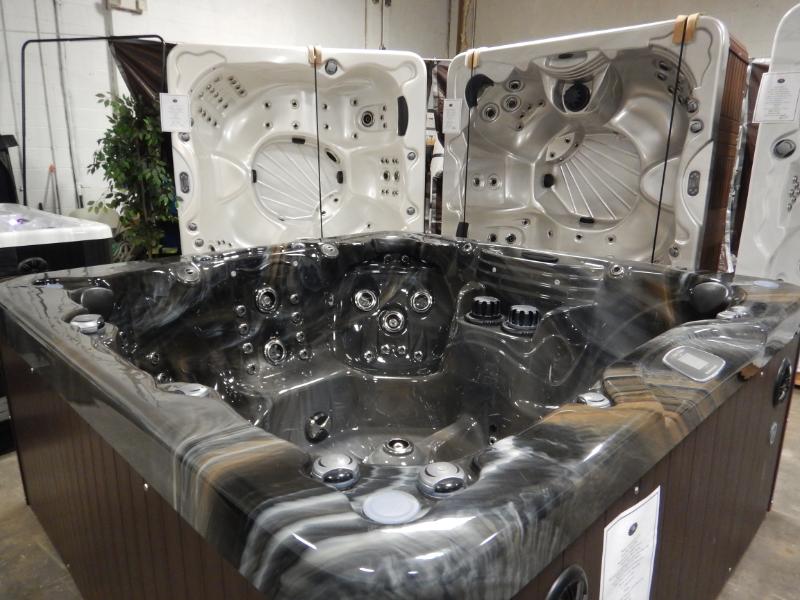 A large hot tub is sitting in a room with other hot tubs