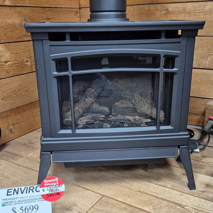 Enviro Westley direct vent gas stove display model with black cast-style freestanding body, arched door, and log set in Olympia WA