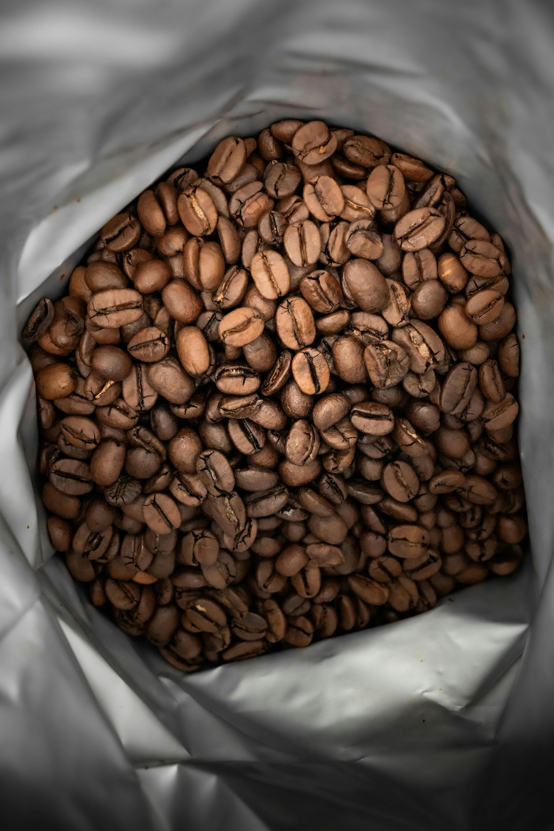A bag filled with coffee beans is sitting on a table.