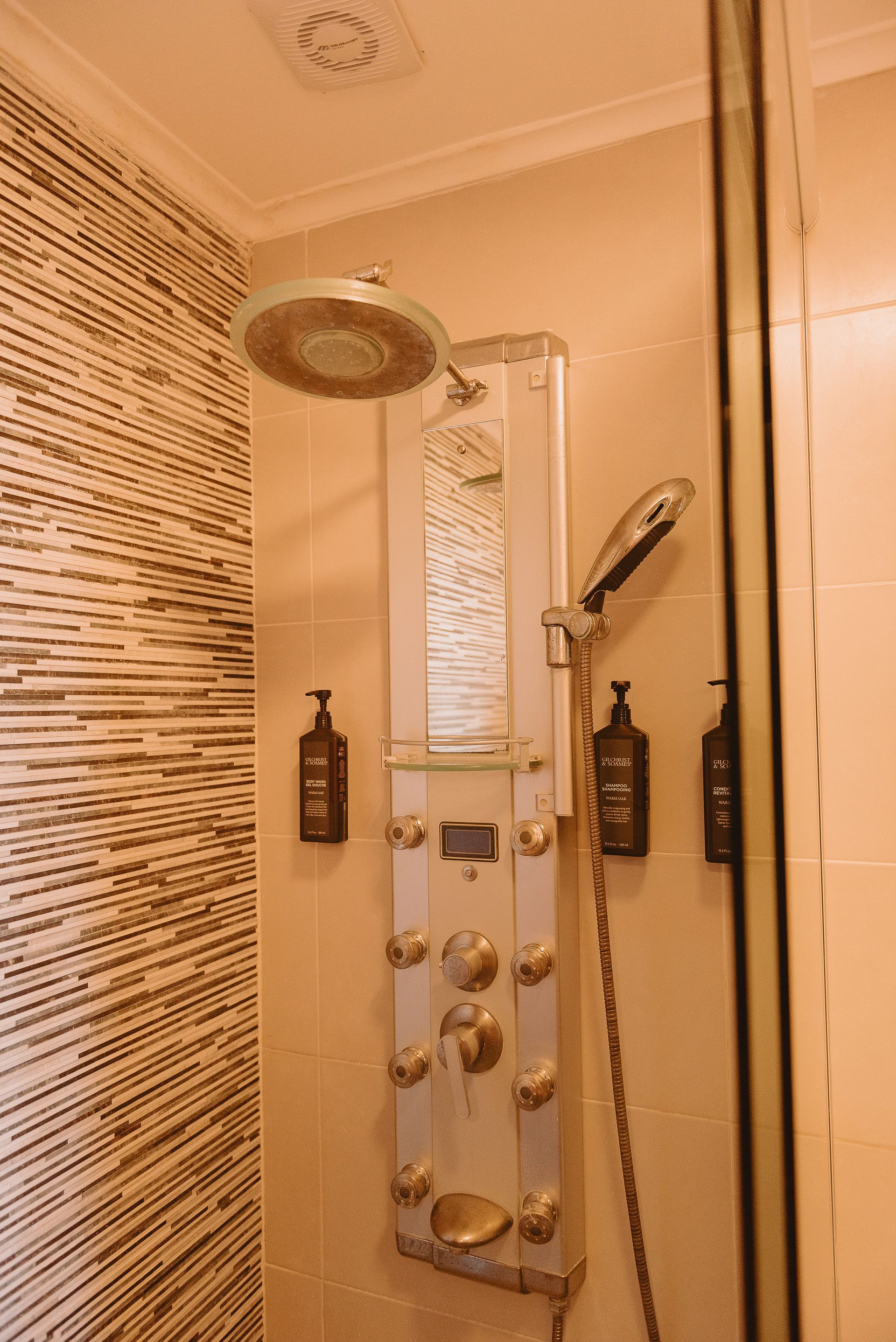 Un baño con ducha, lavabo y espejo.