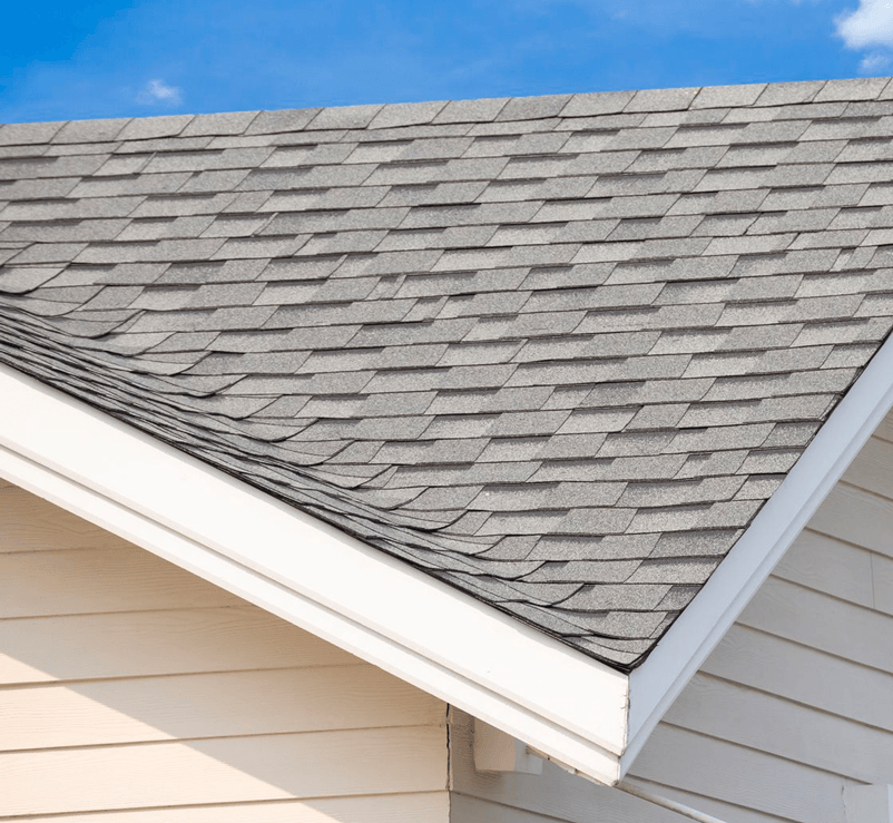 A close up of a roof of a house with a blue sky in the background