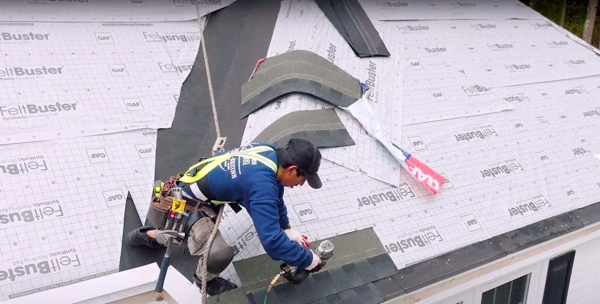 A man is working on the roof of a house.
